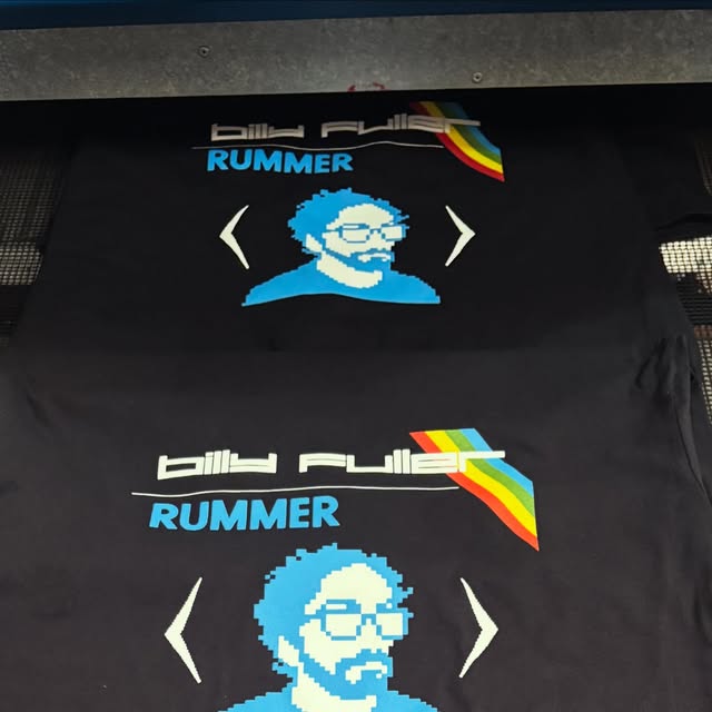 Black Billy Fuller ‘Rummer’ tees on the press, a blue pixel portrait with a rainbow stripe